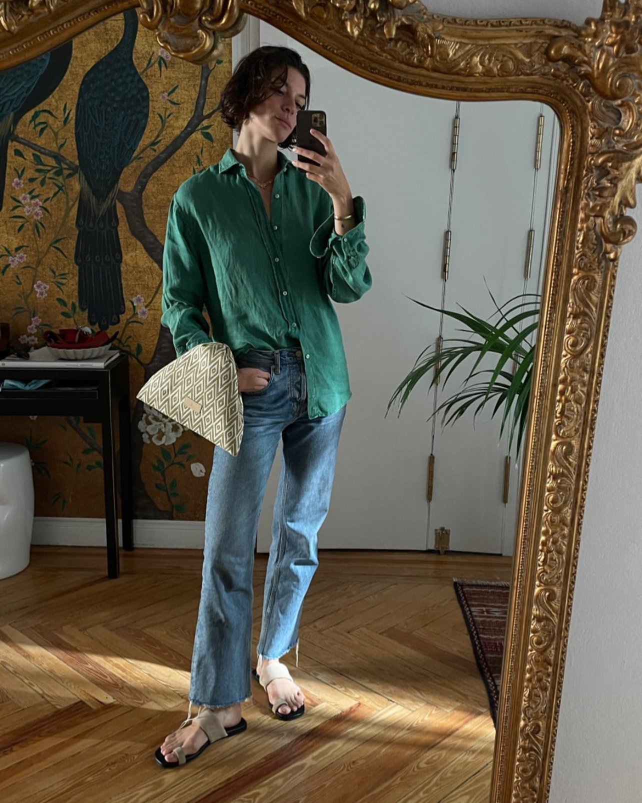 Mujer haciéndose un selfi en el espejo con unas sandalias planas de color beige en ante natural cómodas para looks casuales