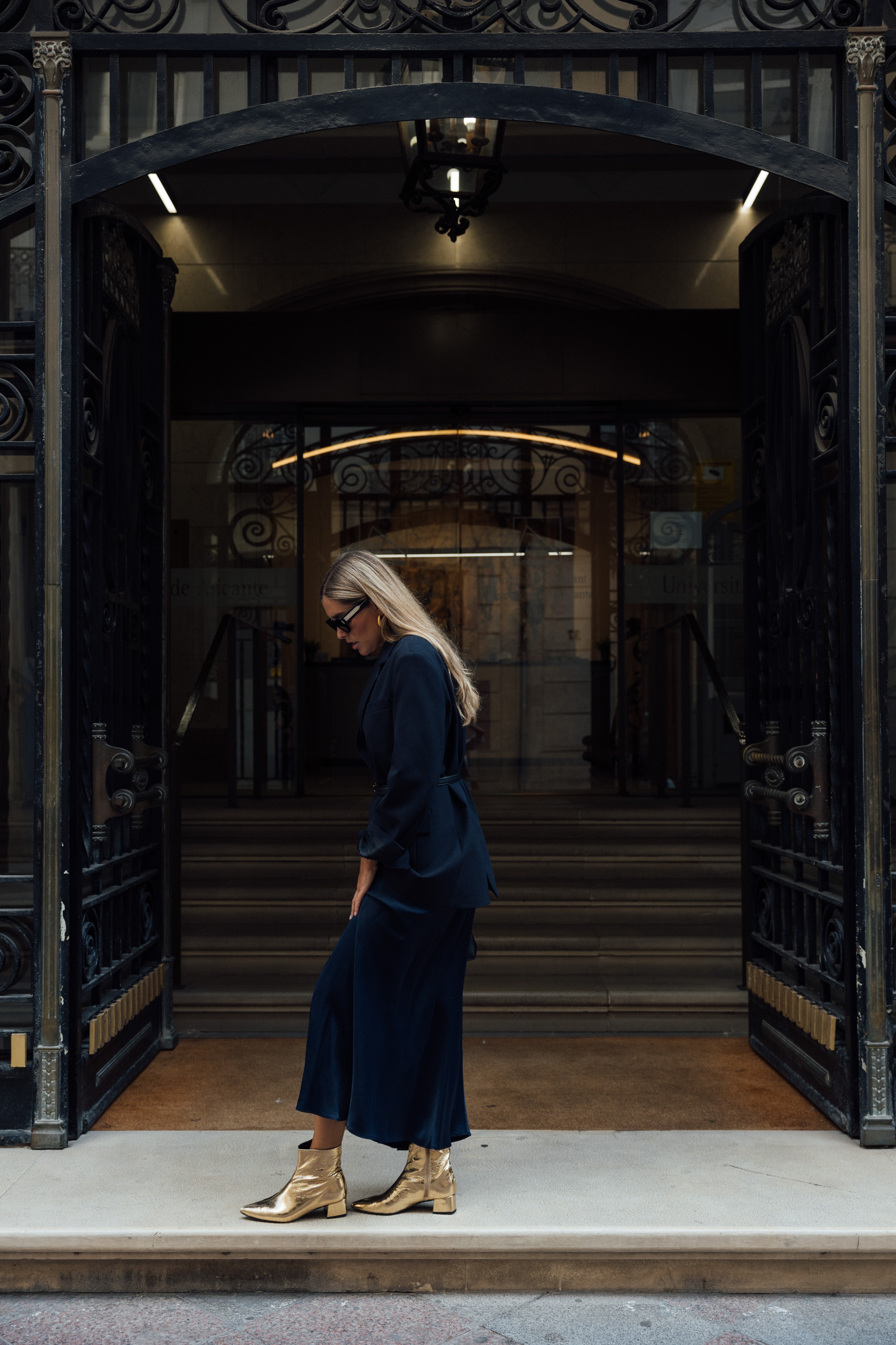 Mujer posando con unos botines de piel laminada dorada