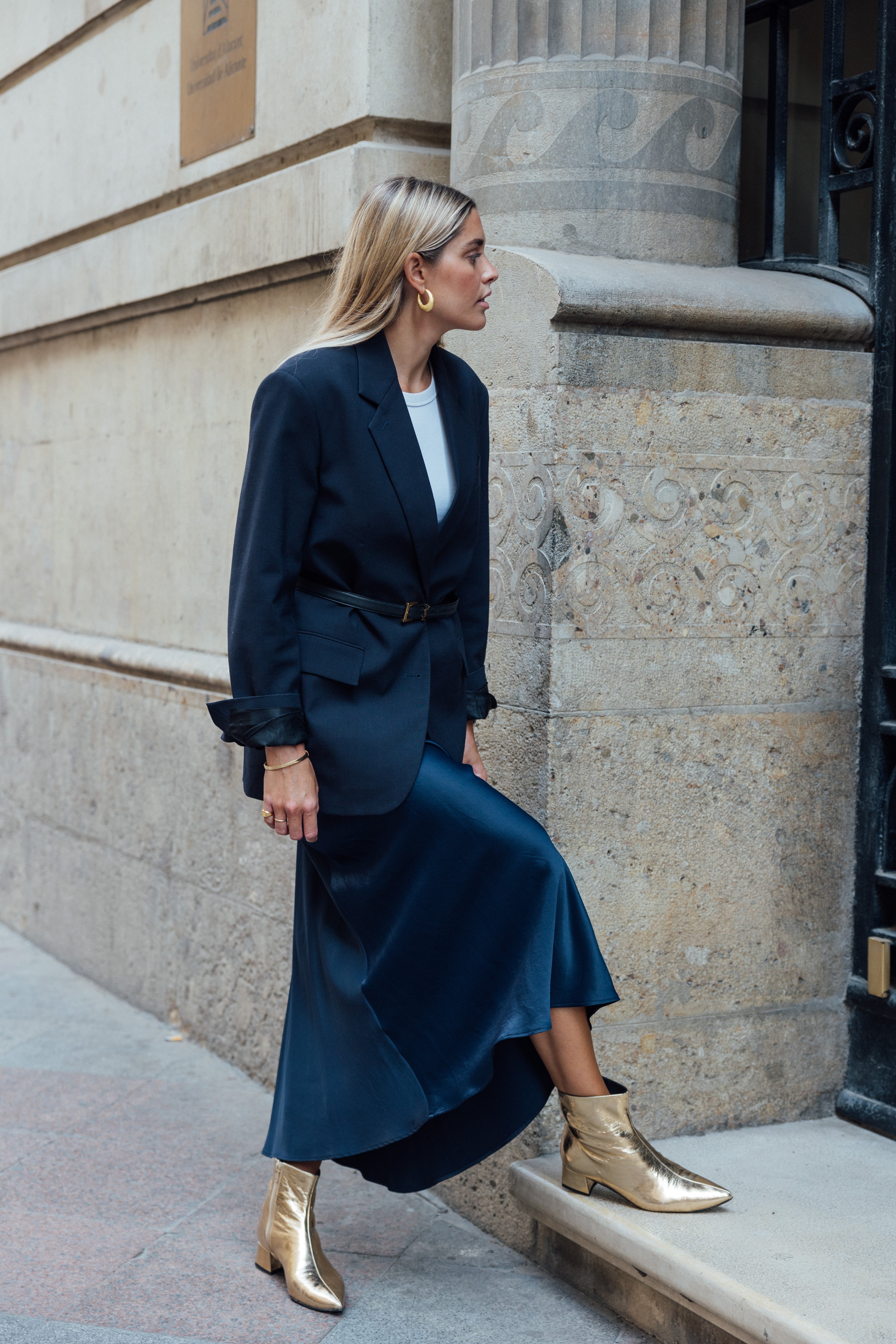 Chica rubia con un par de botines dorados de poco tacón