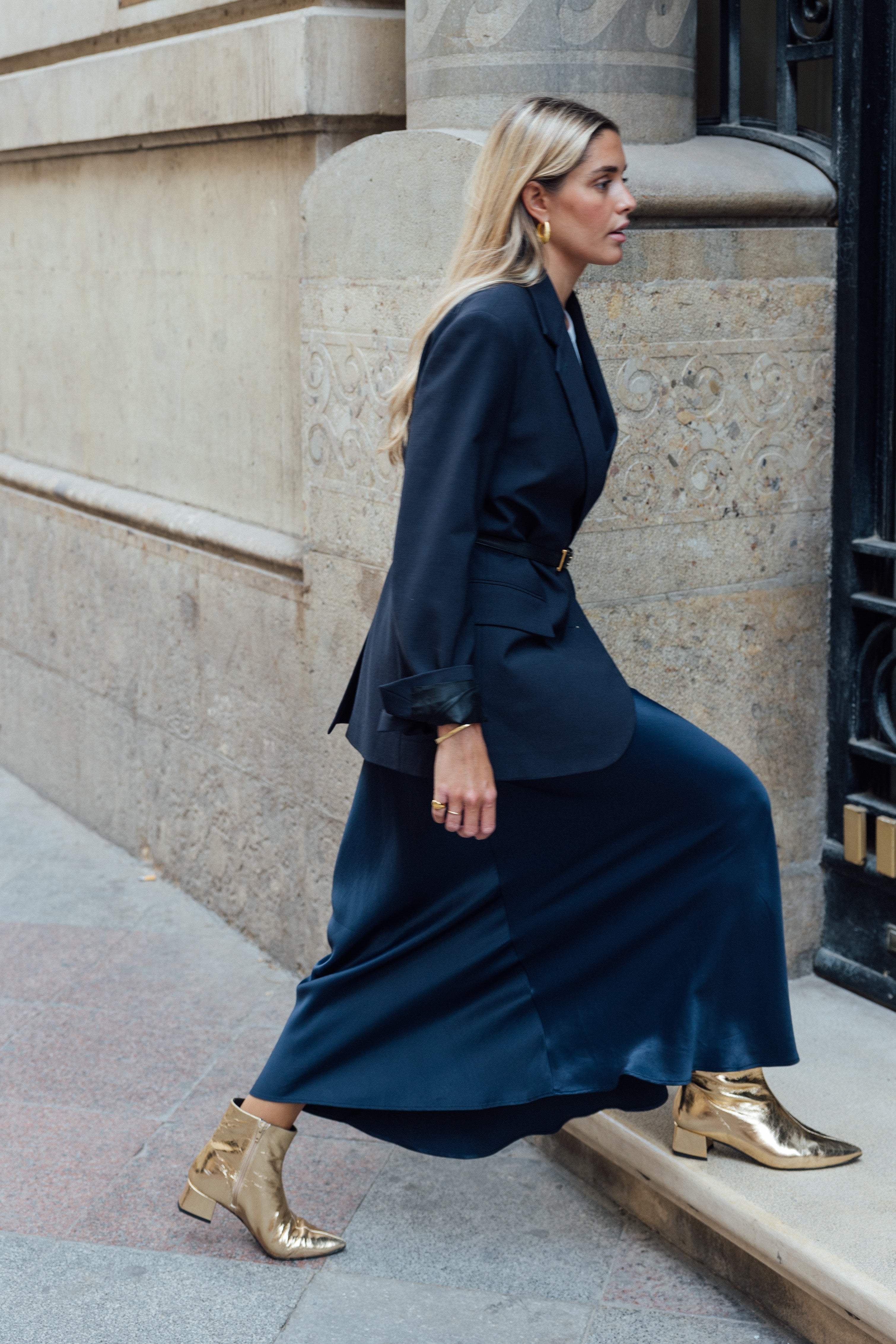 Chica rubia con un par de botines dorados de poco tacón