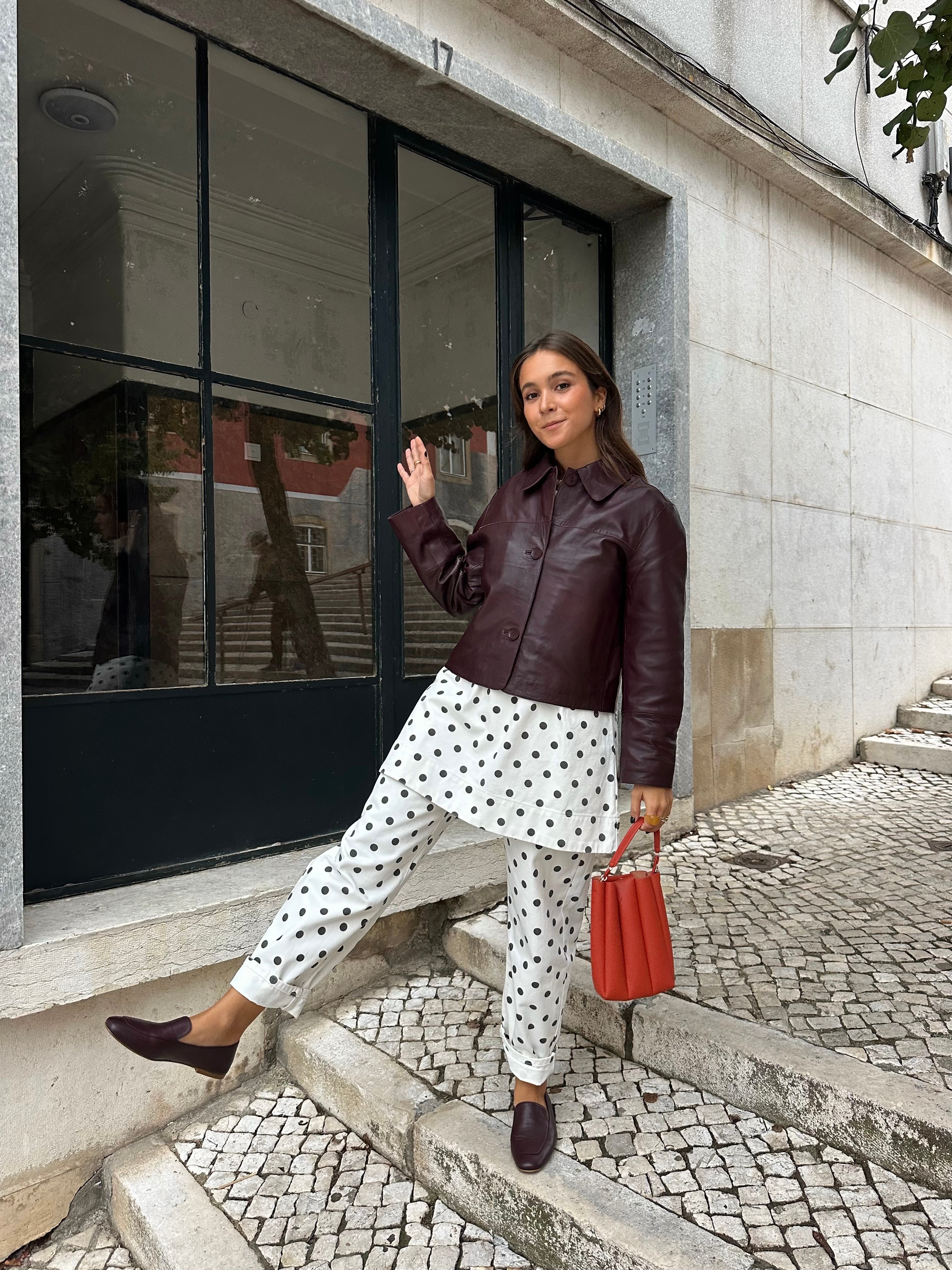 Chica posando con look de lunares y mocasines de piel en color burdeos súper flexibles y cómodos