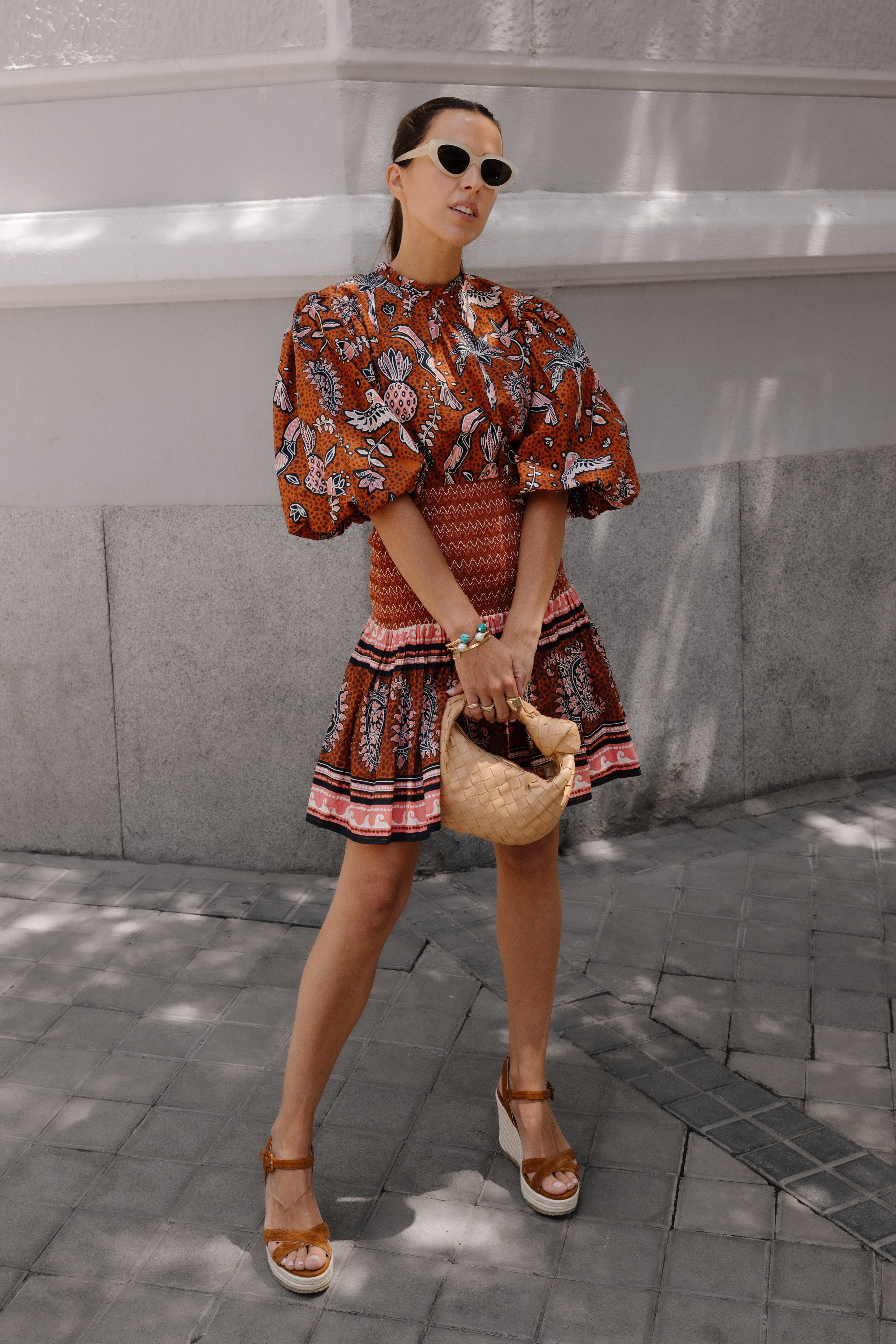 Mujer posando con vestido de color naranja y unas sandalias de cuña de color marrón en piel de ante y con plataforma de corcho