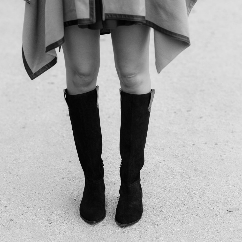 Bota plana de caña alta y punta pronunciada elegante y clásica en ante negro.