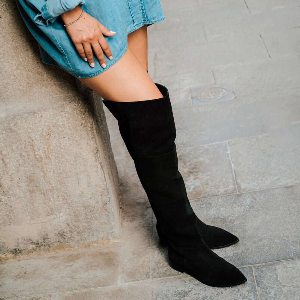 Street style con bota plana mosquetera en ante y piel negra.