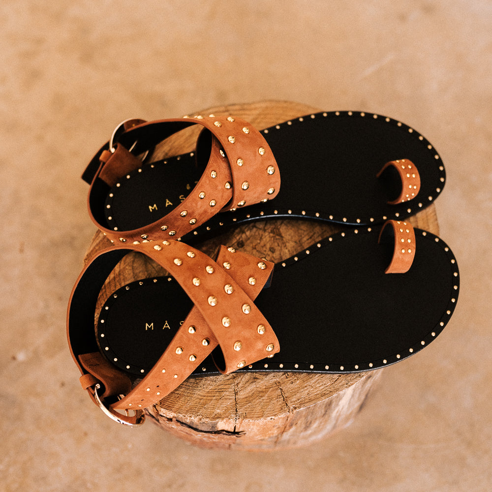 Sandalias planas de verano con tachuelas color oro en ante coñac