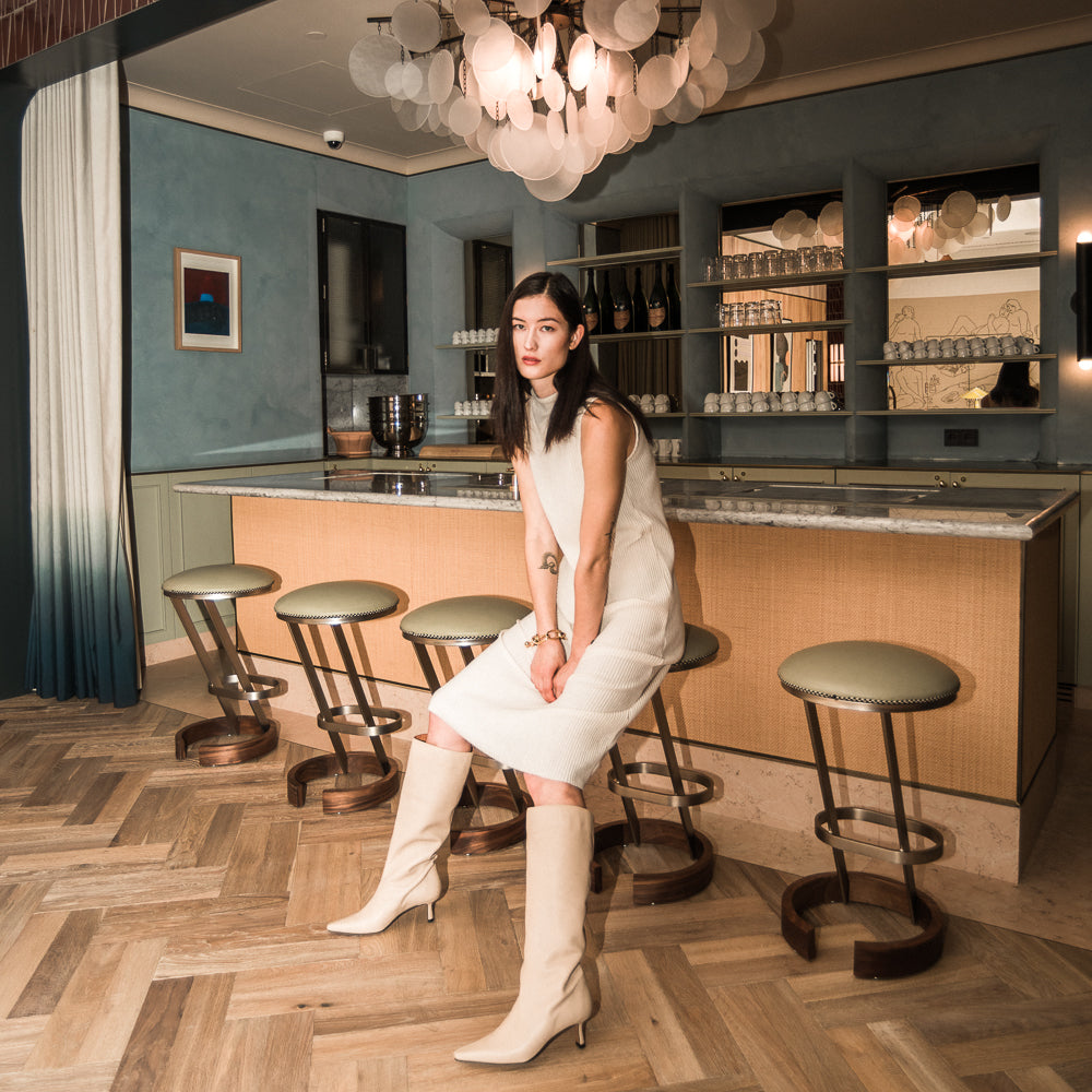 Chica con vestido y botas altas color nude