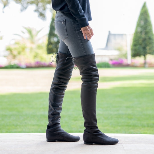 Mujer llevando un par de botas mosqueteras hechas a mano en antelina gris