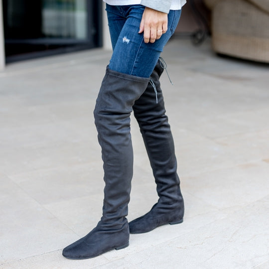 Un par de botas para mujer tipo mosquetero hechas en antelina color gris